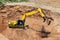 An excavator in a sand pit loads a dump truck with sand. Extraction of sand in an open pit. natural building materials