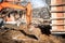 Excavator scoop on construction site, digging and loading dumper trucks.