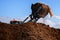 Excavator shovel working on a large heap of manure, organic fert