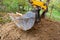 The excavator shovels earth with clay from the pit with a bucket for the construction of a septic tank. Ground work of the machine