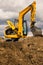 Excavator standing on soil with open engine