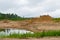 Excavator and tractor at sandpit with water during earthmoving works