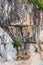 Excavator under massive overhanging rock in quarry