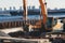 Excavator unloading sand into the dump truck on the construction site, excavating and working during road works, backhoe and