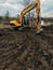 Excavator uprooting trees on land in countryside. Bulldozer clearing land from old trees, roots and branches with dirt and trash.