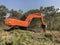 Excavator uproots stumps of cutted trees in the coniferous highland forest