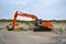 Excavator vehicle for building up sand at beach at Paal 9 after a heavy storm at Texel