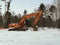 The excavator on a winter road in Siberia