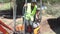 Excavator woman  with yellow warning vest wearing dismount on an excavator