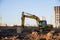 Excavator working at construction site. Backhoe digs ground for the foundation and for paving out sewer line