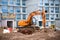 Excavator working at construction site. Backhoe digs ground for the foundation and for paving out sewer line.