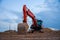 Excavator working at construction site on earthworks. Backhoe digging building foundation. Paving out sewer line. Heavy machinery