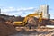 Excavator working at construction site on earthworks. Backhoe digs ground for laying concrete sewage pipes. Installing underground