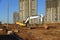 Excavator working at construction site on earthworks. Backhoe on road work digs ground. Paving out sewer line. Construction