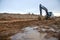 Excavator working at construction site on earthworks. Backhoe on road work digs ground. Paving out sewer line. Construction