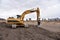 Excavator working at construction site on groundwork. Backhoe digs gravel and concrete crushing. Recycling old concrete from