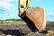 Excavator working in a construction site. Large metal iron ladle. Crusher bucket for crushing concrete.