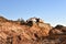 Excavator working on earthmoving at open pit mining. Backhoe digs gravel in quarry. Construction machinery for excavation, loading