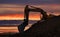 Excavator working on earthmoving on sunset background. Backhoe digs sand and gravel in quarry. Heavy construction equipment during