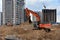 Excavator working at largest construction site. Backhoe on earthworks. Tracked loader laying external sewer pipes. Sewage drainage