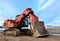 Excavator working in the mining quarry in winter time. Excavator bucket. Large metal iron ladle. Amazing northern sunset on a