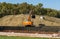 The excavator is working on next stage of construction famous Park Krasnodar. Mountains of soil shape new landscape wonders