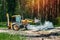 Excavator works on the construction of the railway in the forest. Yellow excavator pours the gravel between the sleepers