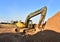 Excavator works on a construction site during excavation work against a blue sky background. Open pit development for sand