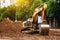 The excavator works on the road in the city for the reconstruction of the water pipeline