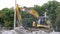 Excavators work on raking concrete blockages at a construction site in the city.