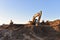 Excavators working at construction site on earthworks. Backhoe digging building foundation. Paving out sewer line. Construction