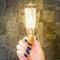 Excellent idea concept, female hand holding classic lit lamp