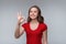 Excellent job. Attractive young brunette woman in red t shirt showing OK sign and smiling, give positive reply