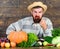 Excellent quality vegetables. Man with beard proud of his harvest vegetables wooden background. Farmer with organic