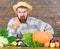 Excellent quality vegetables. Man with beard proud of his harvest vegetables wooden background. Farmer with organic