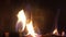 Excellent satisfying close up shot on wood burning slowly with orange fire flame in cozy brickwork fireplace atmosphere