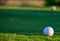 Excellent well-kept green grass lawn on large golf course, green section with big white foam ball for beginners on Tenerife island