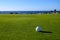 Excellent well-kept green grass lawn on large golf course, green section with big white foam balls for beginners on Tenerife