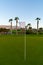 Excellent well-kept green grass lawn on large golf course, green section with white pin on Tenerife island, Canary, Spain