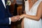 Exchange of wedding rings with closeup bride groom hands