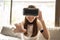 Excite asian woman playing online game with vr glasses and controller at her home