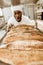 excited african american baker looking at fresh loaves of bread