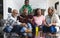 Excited african american parents, son and grandparents watching sport on tv, slow motion