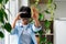 Excited African American teenager girl wearing virtual reality helmet standing in appartment