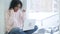 Excited afro-american woman celebrating success, working on laptop, sitting at window