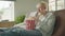 Excited albino man sitting on sofa in living room, eating popcorn, watching TV