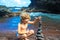 Excited amazed child boy making stones pyramid on pebble beach symbolizing stability, zen, harmony, balance.