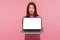 Excited amazed happy woman with brown hair holding laptop with empty screen, showing mock up, blank display for web advertise,