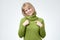 Excited, amazed lady in green sweater smiling showing on self by forefingers