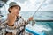 excited Asian fisherman on Strike when fishing at sea